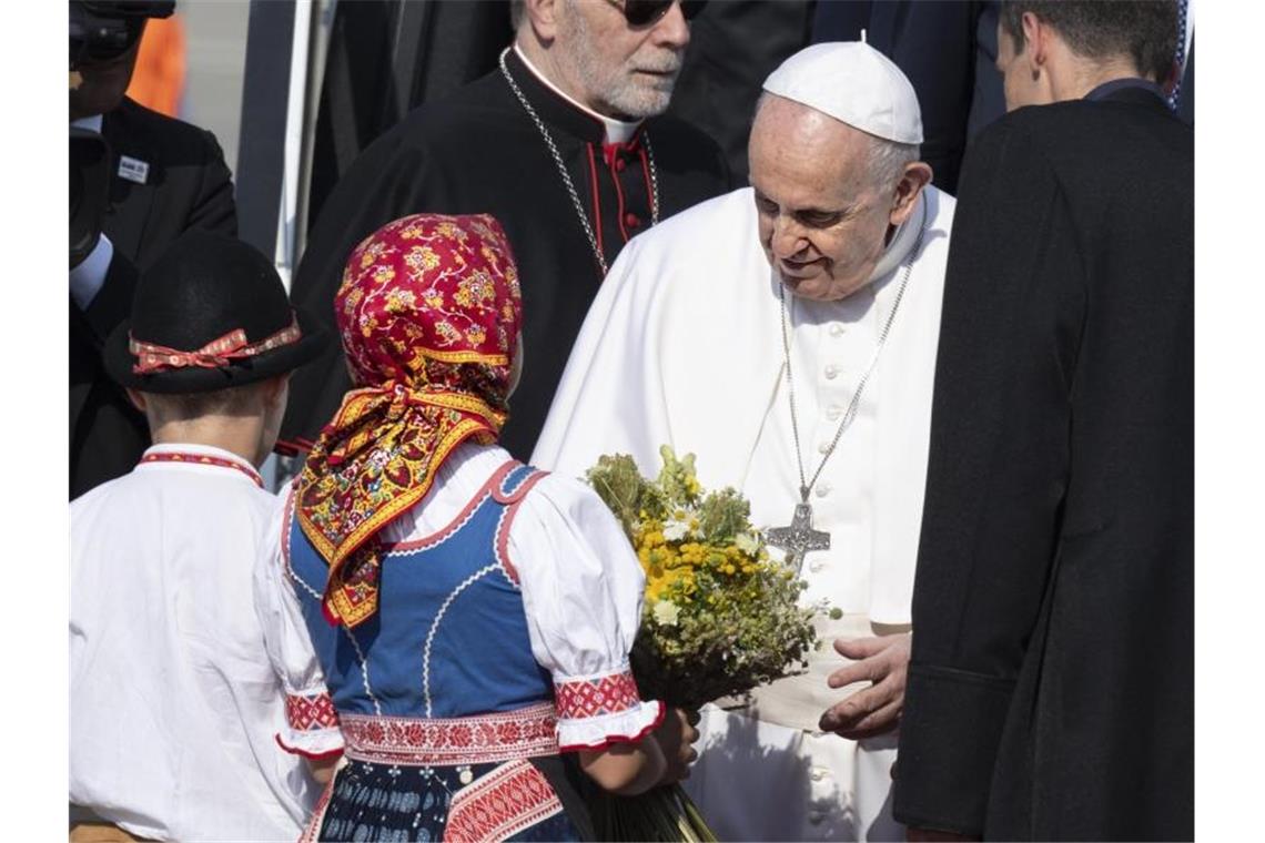 Papst besucht Holocaust-Mahnmal und Nonnen in Bratislava Papst Franziskus wird von zwei Kindern in traditioneller Kleidung am Flughafen im slowakischen Bratislava empfangen. Foto: Pavel Neubauer/TASR/dpa