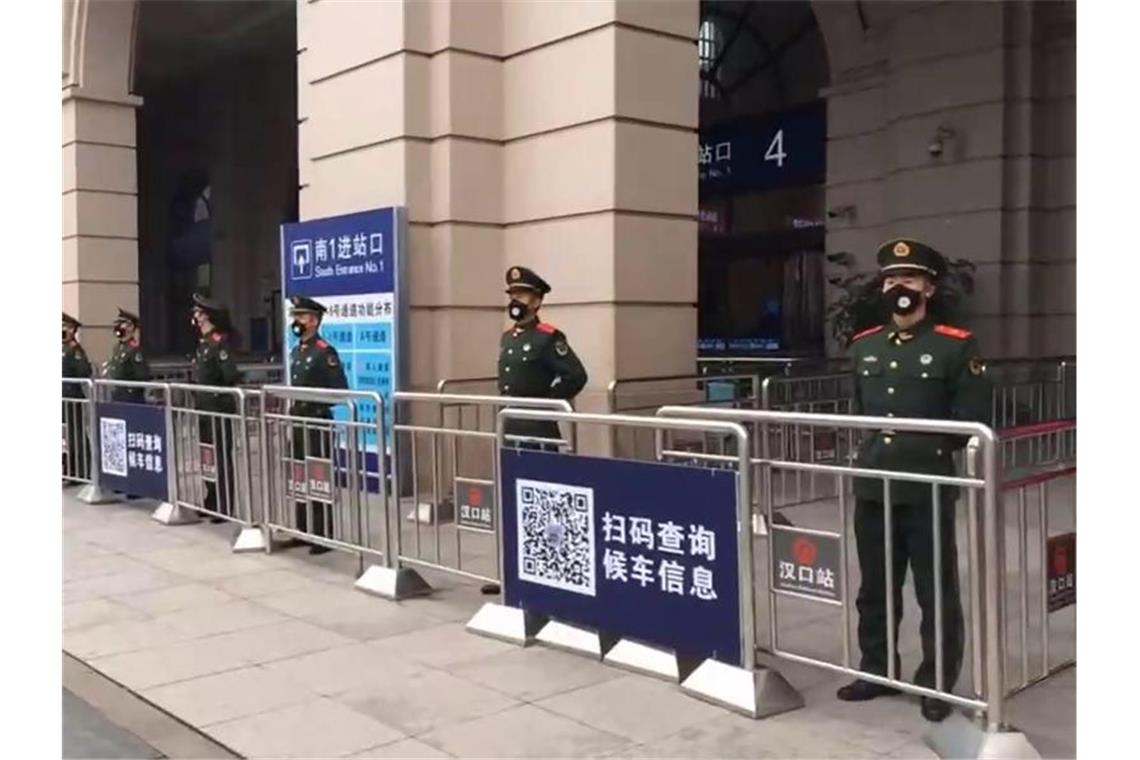 Paramilitärische Polizei hat einen Bahnhof in der Metropole Wuhan abgeriegelt. Foto: Uncredited/The Paper/dpa