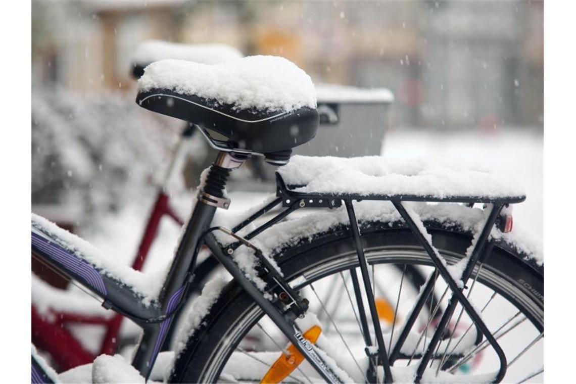 Parkende Fahrräder sind mit Schnee bedeckt. Foto: Matthias Bein/dpa-Zentralbild/dpa/Archiv