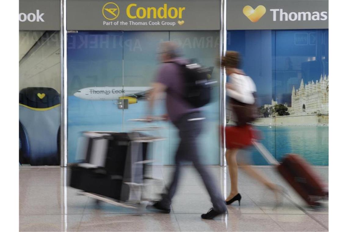 Thomas Cook warnt Kunden vor E-Mail-Betrugsmasche Passagiere gehen an einem Büro von Condor und Thomas Cook am Flughafen Palma de Mallorca vorbei. Foto: Clara Margais