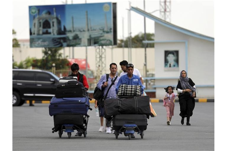 Passagiere gehen zum Abflugterminal des internationalen Flughafens Hamid Karzai in Kabul, Afghanistan, Samstag, 14. August 2021. Da die afghanische Hauptstadt von einer Taliban-Offensive umzingelt ist, gibt es für diejenigen, die vor dem Krieg fliehen, zunehmend nur noch einen Weg nach draußen. Foto: Rahmat Gul/AP/dpa