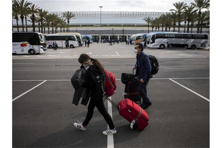 Passagiere mit Mund-Nasen-Schutz kommen am Flughafen Palma de Mallorca an. Foto: Francisco Ubilla/AP/dpa