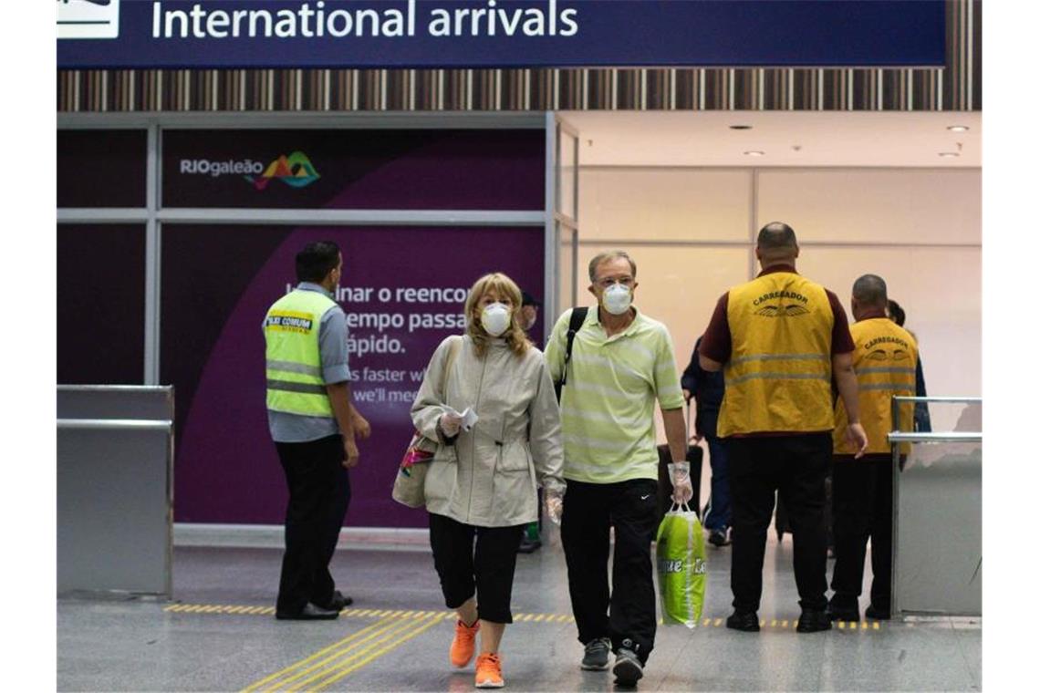 Passagiere mit Mundschutz bei ihrer Ankunft am Flughafen von Rio de Janeiro. Foto: Diego Marinho/Am Press/AM Press via ZUMA Wire/dpa