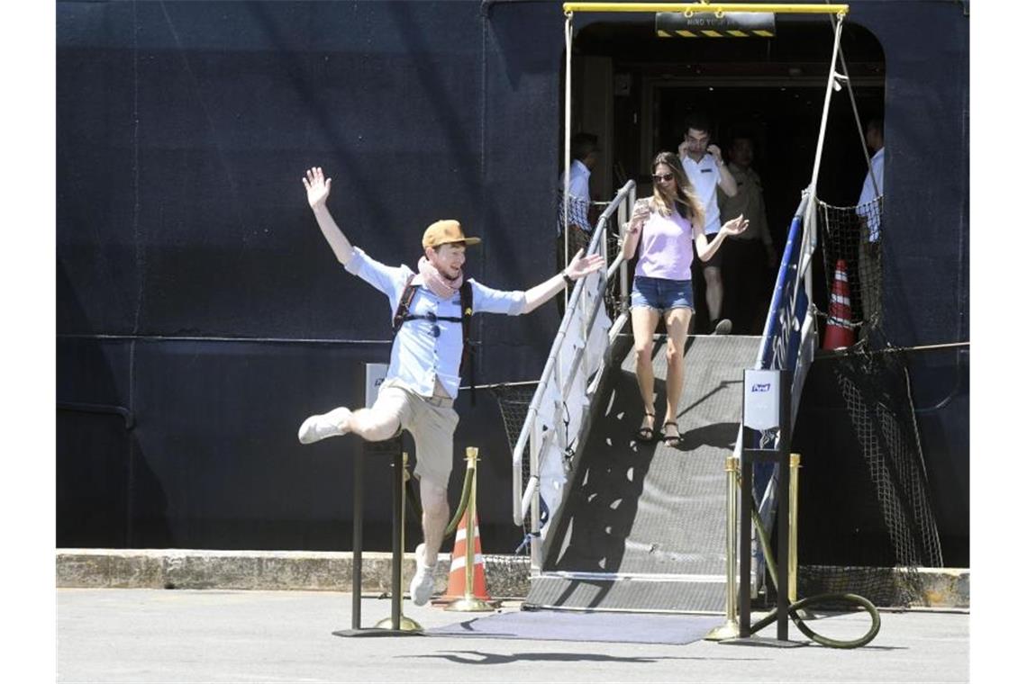 Passagiere reagieren voller Freude, während sie das Kreuzfahrtschiff „Westerdam“ im Hafen von Sihanoukville verlassen. Foto: kyodo/dpa