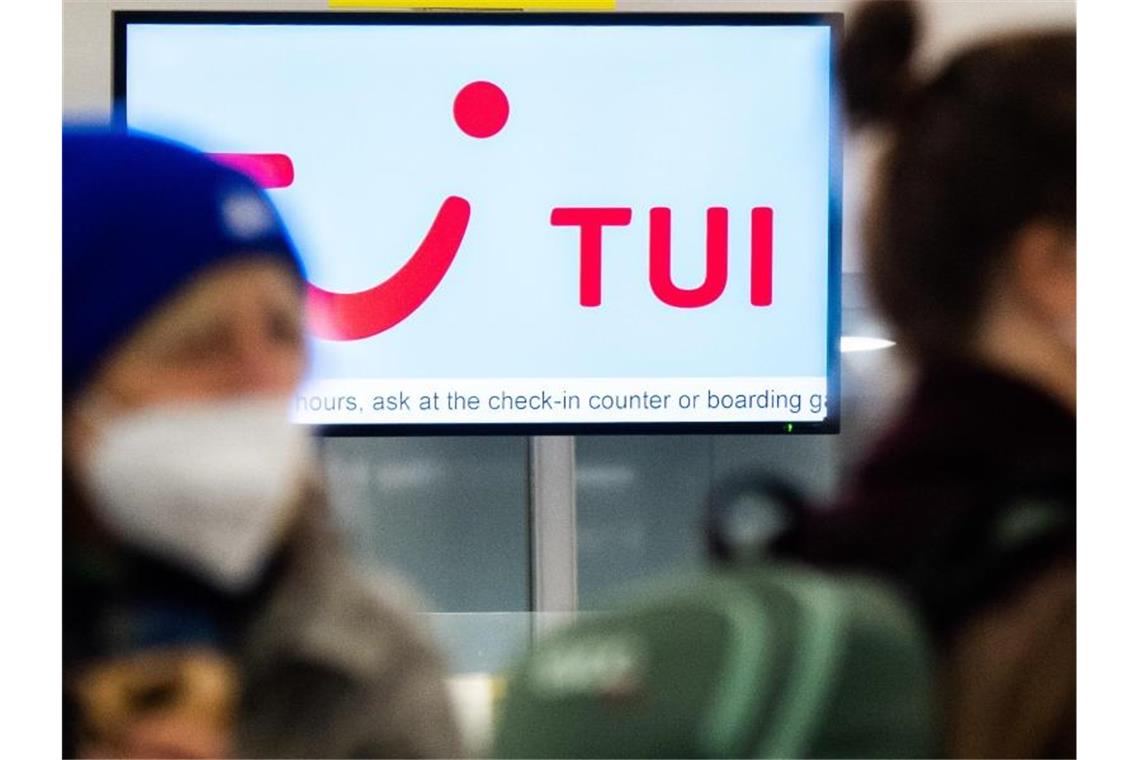 Tui sieht Comeback und will Hilfen zurückzahlen Passagiere stehen am Flughafen am Check-Inn für einen Tuifly Flug. Foto: Julian Stratenschulte/dpa