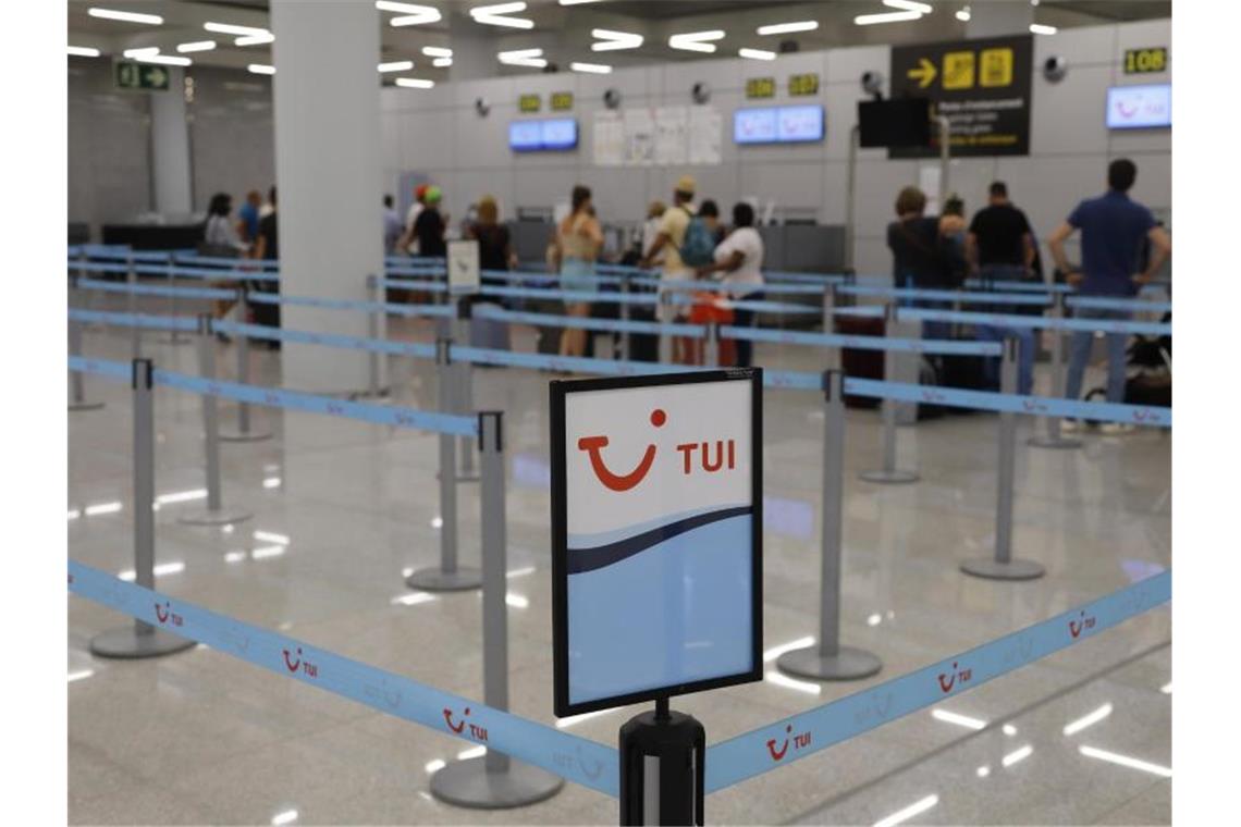 Tui verdoppelt Mallorca-Flüge zu Ostern Passagiere stehen am Flughafen Palma am Abfertigungsschalter von Tui. Foto: Clara Margais/dpa