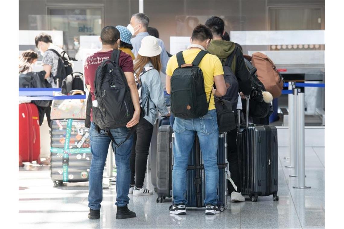Reisebuchungen steigen von Woche zu Woche Passagiere stehen beim Check-in am Frankfurter Flughafen Schlange. Foto: Boris Roessler/dpa