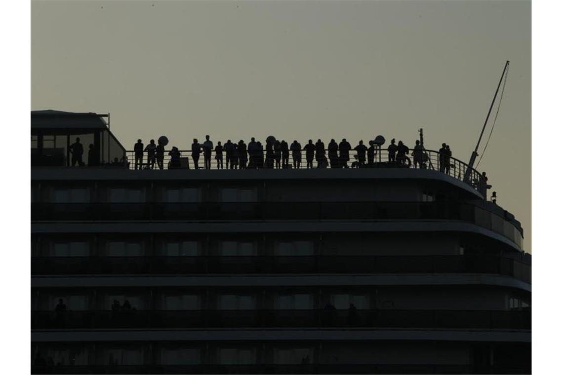 Passagiere und Besatzung stehen auf der Reling des Kreuzfahrtschiffes „Westerdam“ im Hafen von Sihanoukville. Foto: Heng Sinith/AP/dpa