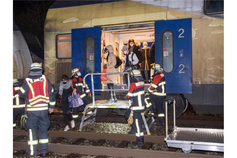 Passagiere verlassen mit Hilfe von Feuerwehrleuten einen Nahverkehrszug, dessen Lok auf der Bahnstrecke Hamburg - Bremen mit einem Baum kollidiert war. Foto: Joto/dpa