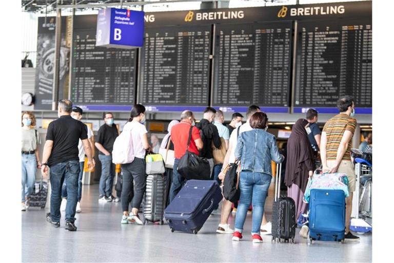Passagiere warten auf dem Frankfurter Flughafen. Foto: Boris Roessler/dpa
