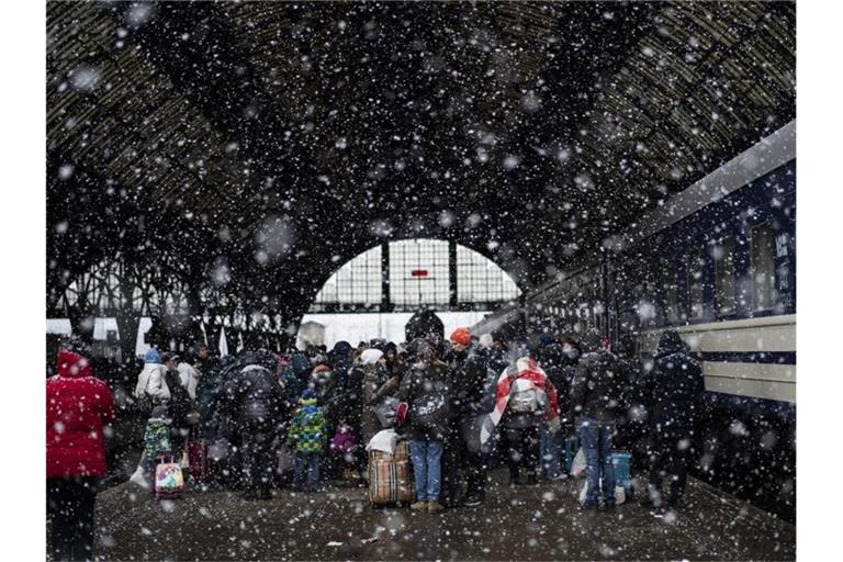Passagiere warten auf einen Zug nach Polen im Bahnhof von Lwiw. Foto: Bernat Armangue/AP/dpa