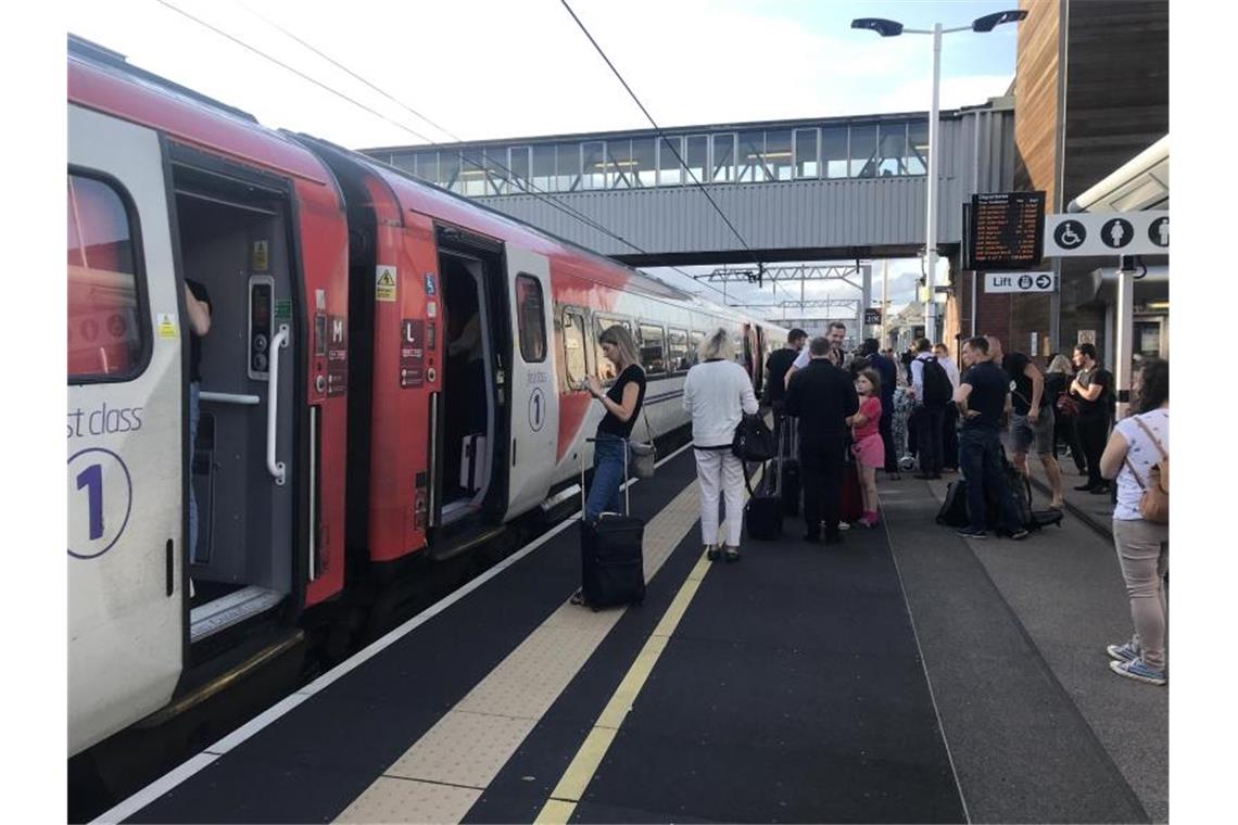 Passagiere warten auf Nachrichten am Bahnhof von Peterborough, da der Reiseverkehr eingestellt ist. Teile Großbritanniens, von der Ostküste bis nach London, sind von einem Stromausfall betroffen. Foto: Martin Keene/PA Wire