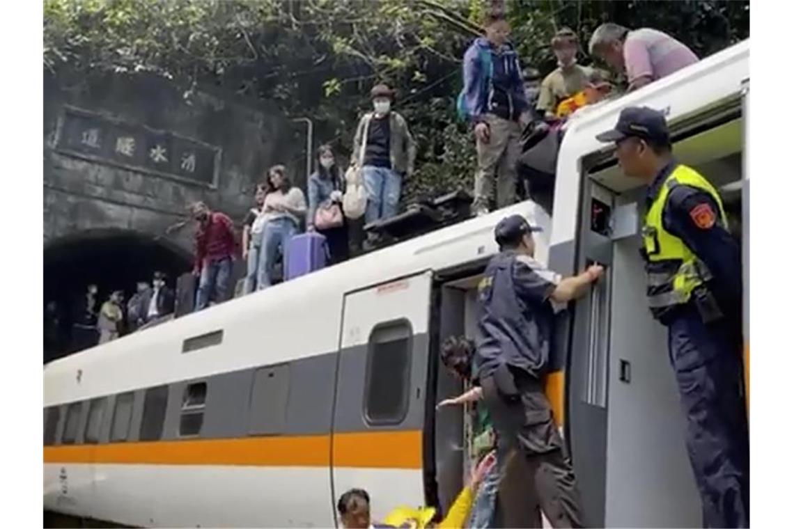 Passagieren wird geholfen, aus dem entgleisten Zug zu klettern. Foto: Uncredited/hsnews.com.tw/AP/dpa