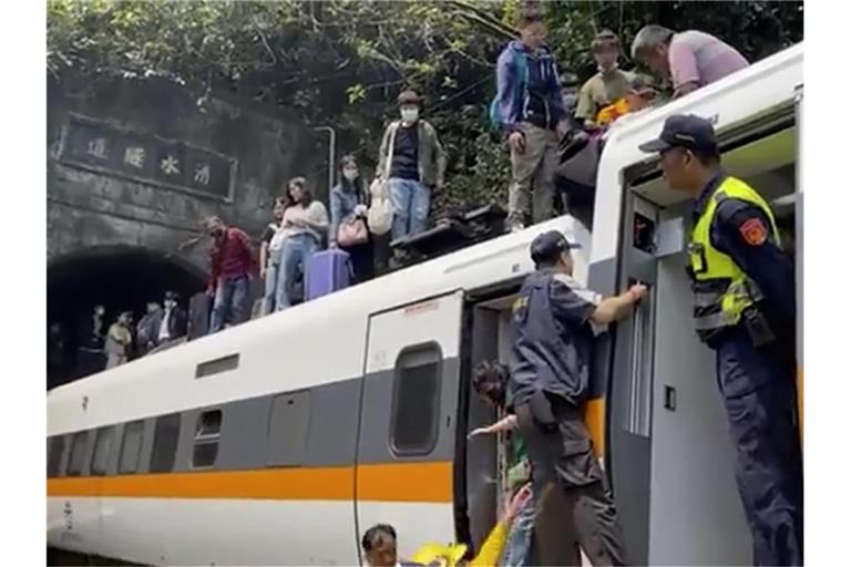 Passagieren wird geholfen, aus dem entgleisten Zug zu klettern. Foto: Uncredited/hsnews.com.tw/AP/dpa