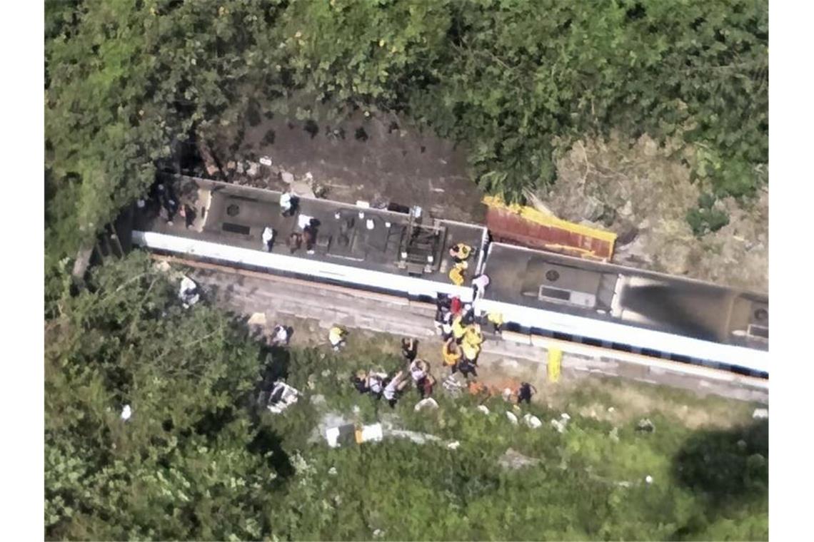Mindestens 51 Tote bei schwerem Zugunglück in Taiwan Passagieren wird geholfen, aus einem entgleisten Zug zu klettern (bestmögliche Qualität). Nach dem Zugunglück in Taiwan gibt es viele Todesopfer. Foto: Uncredited/National Fire Agency/AP/dpa