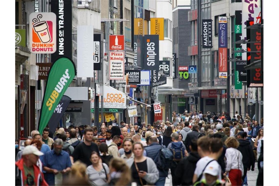 Passanten bummeln auf der Hohen Straße, einer Fußgängerzone in der Kölner Innenstadt. Foto: Henning Kaiser/dpa