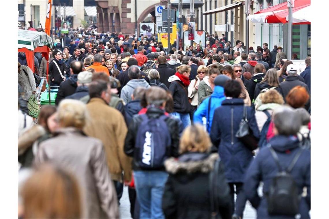 Studie: Viel Hilfsbereitschaft in Freiburg und Mannheim Passanten flanieren durch eine Fußgängerzone und bummeln an den Schaufenstern vorbei. Foto: Jan Woitas/Archivbild