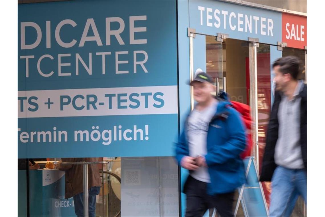 Passanten gehen an einem Corona-Testzentrum in der Münchner Innenstadt vorbei. Foto: Peter Kneffel/dpa