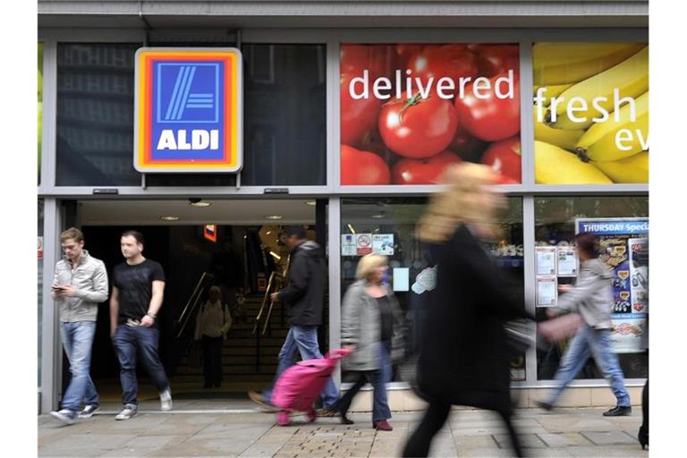 Passanten gehen in der Innenstadt von Manchester, Großbritannien, an einer Filiale von Aldi vorbei. Foto: Marius Becker/dpa