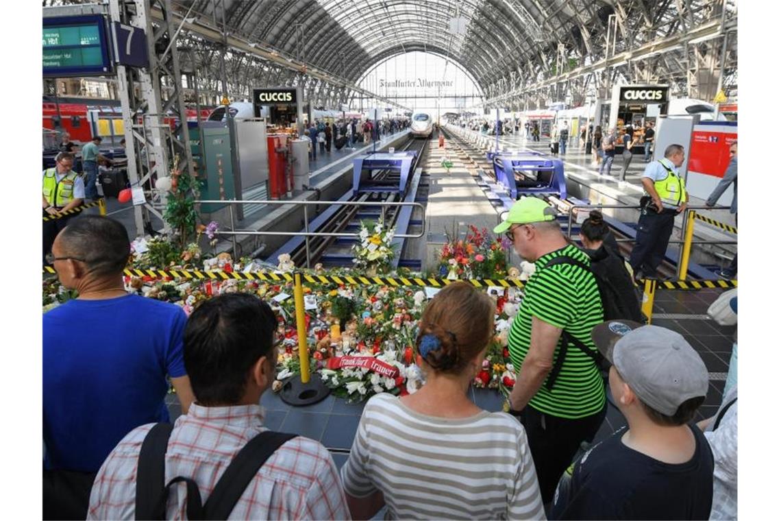 Nach Gleis-Attacke Debatte über Sicherheit an Bahnhöfen Passanten stehen am Gleis 7 des Frankfurter Hauptbahnhofs vor einem Meer aus Blumen und Kuscheltieren. Foto: Arne Dedert
