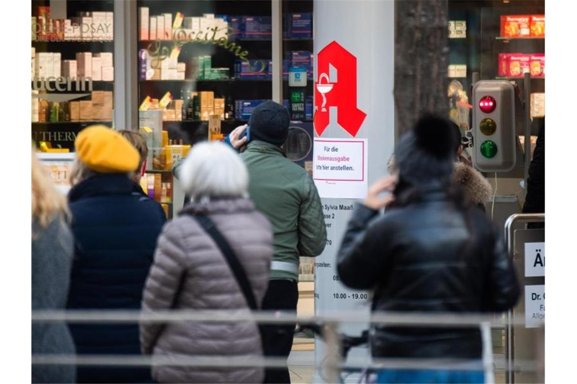 Passanten stehen Schlange vor einer Apotheke. Der von Apotheken ausgestellte digitale Impfnachweis ist eine freiwillige Ergänzung des weiter gültigen gelben Impfheftes aus Papier. Foto: Julian Stratenschulte/dpa