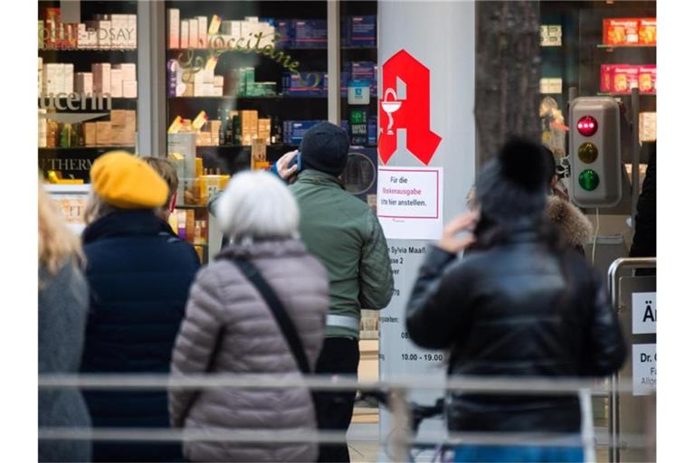 Passanten stehen Schlange vor einer Apotheke. Der von Apotheken ausgestellte digitale Impfnachweis ist eine freiwillige Ergänzung des weiter gültigen gelben Impfheftes aus Papier. Foto: Julian Stratenschulte/dpa