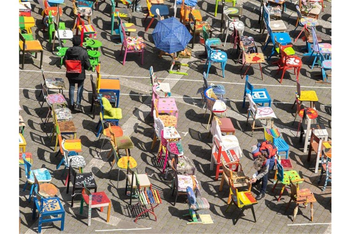 Stuttgart: Hunderte „Asylstühle“ tauchen Marktplatz in Farbe Passanten stehen zwischen den „Asylstühlen“ auf dem Stuttgarter Marktplatz. Foto: Sebastian Gollnow/Archivbild