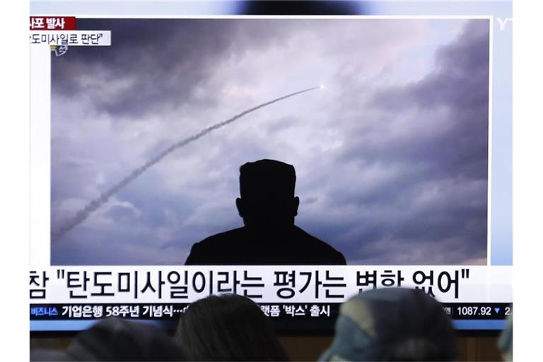 Passanten verfolgen an einem Bahnhof auf einem Fernseher eine Nachrichtensendung über einen Raketentest von Nordkorea. Foto: Ahn Young-Joon/AP