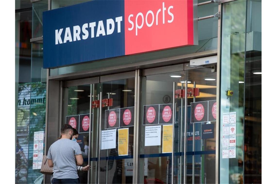Passanten vor einem Eingang einer Filiale von Karstadt Sports. Foto: Bernd Thissen/dpa