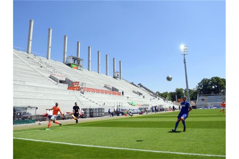 Patrick Herrmann von Darmstadt 98 (l) und Damian Rossbach vom KSC (r) spielen vor leeren Rängen. Foto: Matthias Hangst/Getty-Pool/dpa