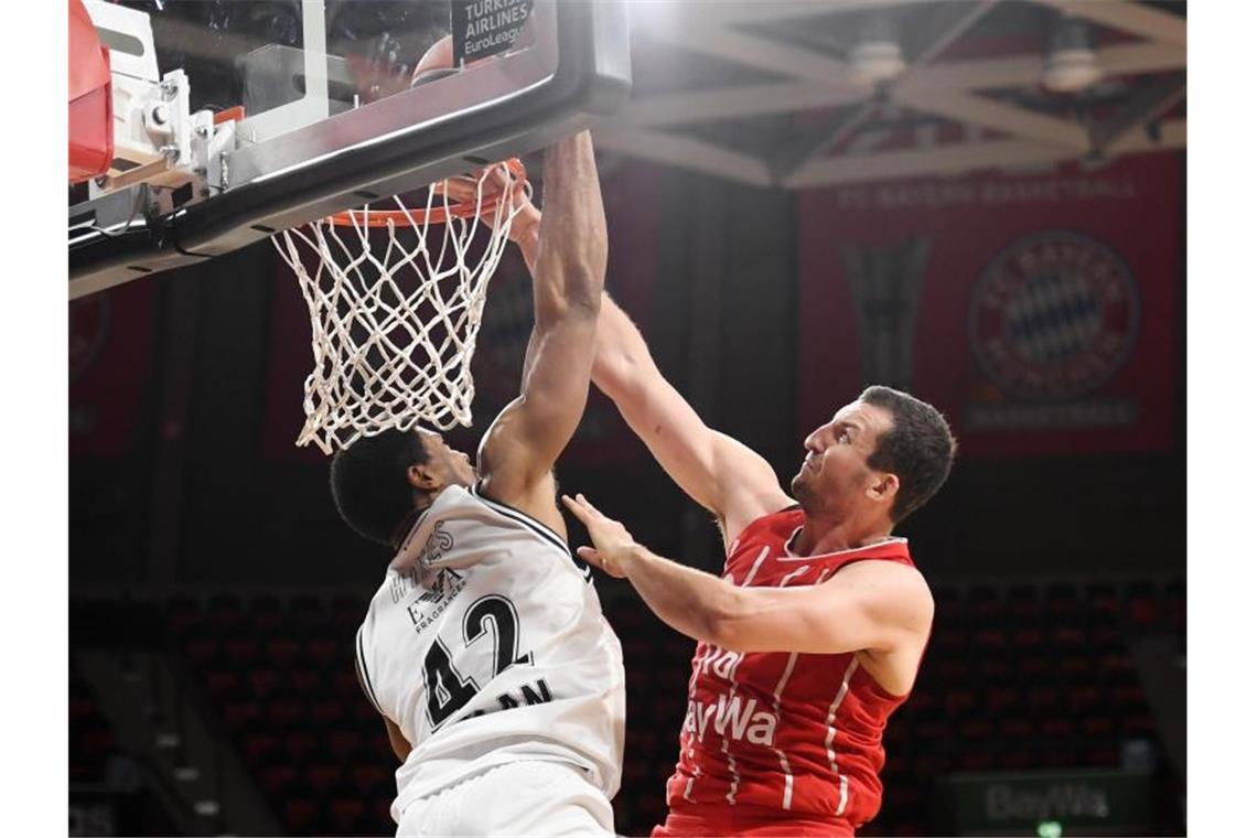 Sieg über Mailand: Bayern-Basketballer erzwingen Showdown Paul Zipser (r) punktet für Bayern München gegen die Verteidigung von Mailands Kyle Hines. Foto: Tobias Hase/dpa