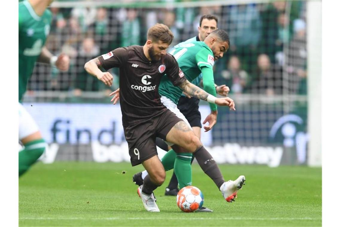 Pauli weiterhin Tabellenführer - Sandhausen schlägt Dresden Pauli-Torjäger Guido Burgstaller (vorne) schirmt den Ball gegen Werders Jean Manuel Mbom ab. Foto: Carmen Jaspersen/dpa