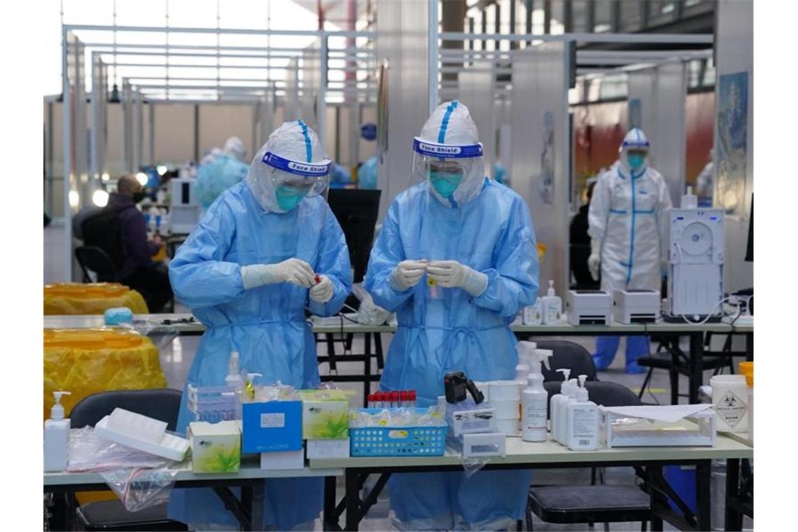 24 weitere Corona-Fälle vor Olympia PCR-Prüfer in Schutzanzügen arbeiten in einem Prüfzentrum auf dem Flughafen von Peking. Foto: Andrew Milligan/PA Wire/dpa