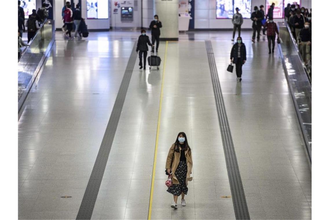Pendler in Hongkong tragen Mundschutz in einer U-Bahnstation. Foto: Miguel Candela/SOPA Images via ZUMA Wire/dpa
