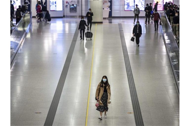 Pendler in Hongkong tragen Mundschutz in einer U-Bahnstation. Foto: Miguel Candela/SOPA Images via ZUMA Wire/dpa