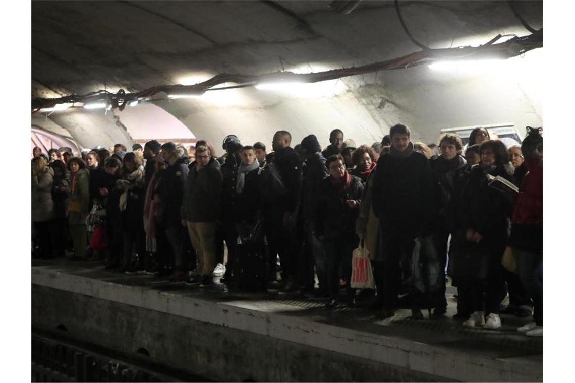 Pendler warten an einem Bahnsteig in Paris vergeblich auf eine U-Bahn. Foto: Michel Euler/AP/dpa