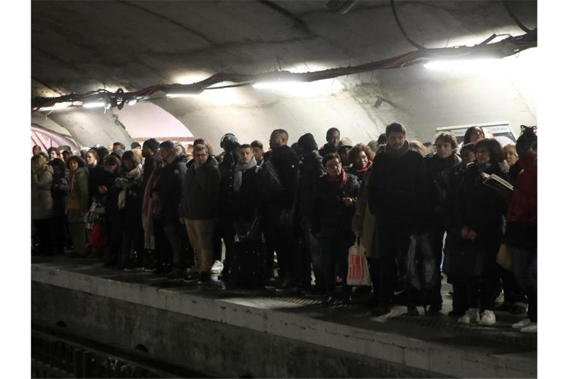 Streiks in Frankreich dauern auch am Wochenende an Pendler warten an einem Bahnsteig in Paris vergeblich auf eine U-Bahn. Foto: Michel Euler/AP/dpa