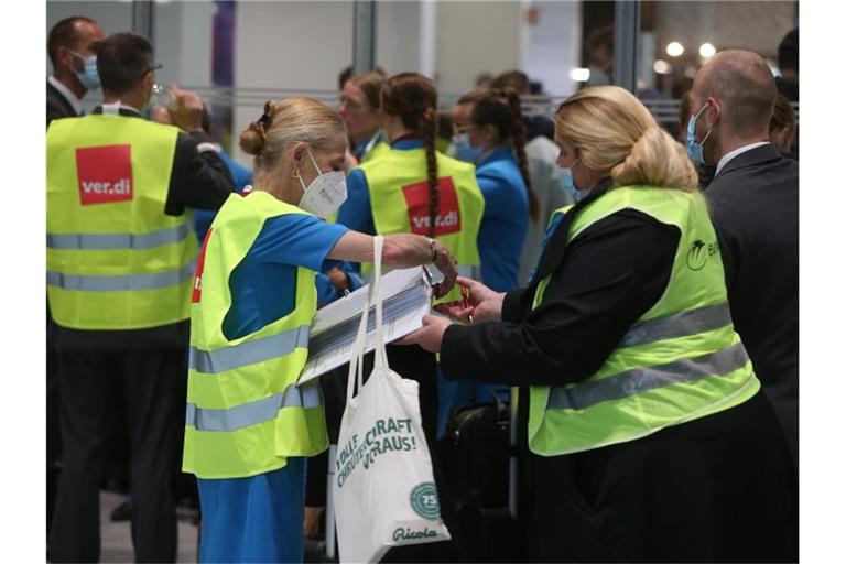 Personal der Eurowings steht beim Warnstreik mit verdi-Westen im Flughafen und trägt sich in Listen für Streikgeld ein. Foto: David Young/dpa