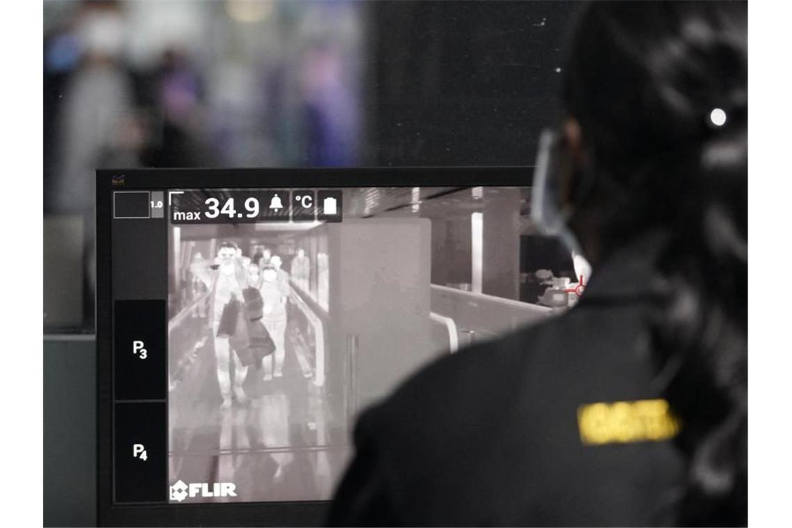 Personal der malaysischen Gesundheitsbehörde überprpüft am internationalen Flughafen Kuala Lumpur Reisende mit Wärmebildscannern. Foto: Vincent Thian/AP/dpa