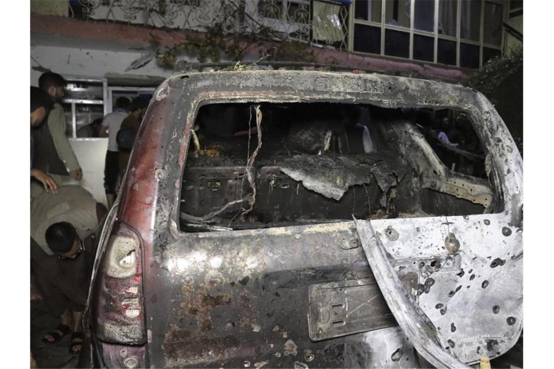 US-Militär greift mit Drohne in Kabul an Personen betrachten ein ausgebranntes Fahrzeug in Kabul, das bei einem amerikanischen Drohnenangriff ins Visier genommen wurde. Foto: Khwaja Tawfiq Sediqi/AP/dpa