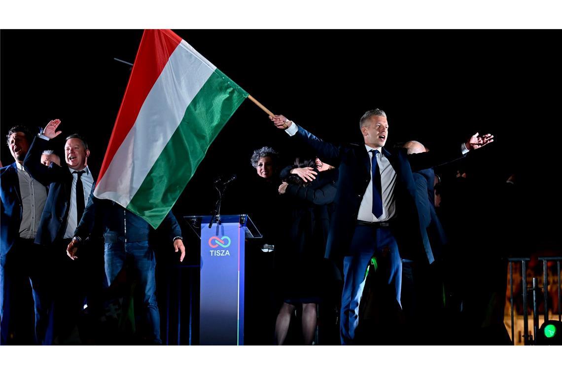 Peter Magyar, Vorsitzender der Oppositionspartei Tisza, schwenkt die ungarische Flagge nach der Bekanntgabe der Teilergebnisse der Parlamentswahl in Ungarn.