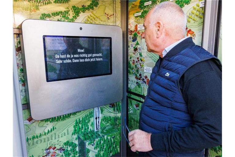 Peter Weber (parteilos), Gemeindepräsident von Mettauertal, steht in der zur "Schulterklopfmaschine" umgebauten Telefonzelle. Foto: Philipp von Ditfurth/dpa