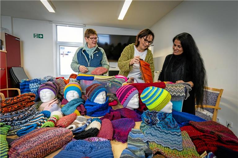 Petra Brinckmann (von links), Sabine Schopf und Christina Demertzi bewundern die zahlreichen Schals, Mützen und Socken, welche die Erlacher Höhe nun als Spende bekommen hat. Foto: Alexander Becher