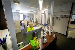 Petra Große ist von einer Plexiglasscheibe geschützt. Seit der Coronapandemie setzen viele Arztpraxen noch immer darauf.