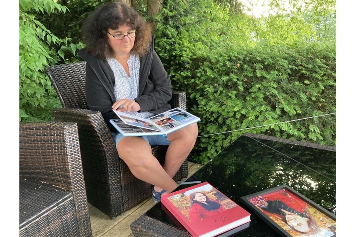 Petra Lieser sitzt mit Fotobüchern über ihre Tochter in ihrem Garten. Die Tochter Katja Lieser war am 1. Dezember 2020 bei einer Amokfahrt in Trier getötet worden (zu dpa „„Der Schmerz hört nicht auf“: Das Leben nach der Amokfahrt von Trier“). Foto: Birgit Reichert/dpa