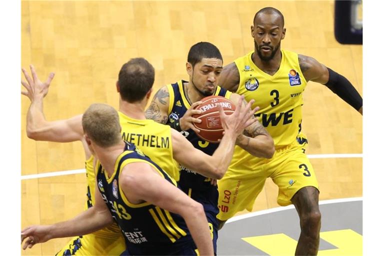 Peyton Siva (2.v.r) zieht gegen Philipp Schwethelm (2.v.l) und William Cummings (r) zum Korb. Foto: Friso Gentsch