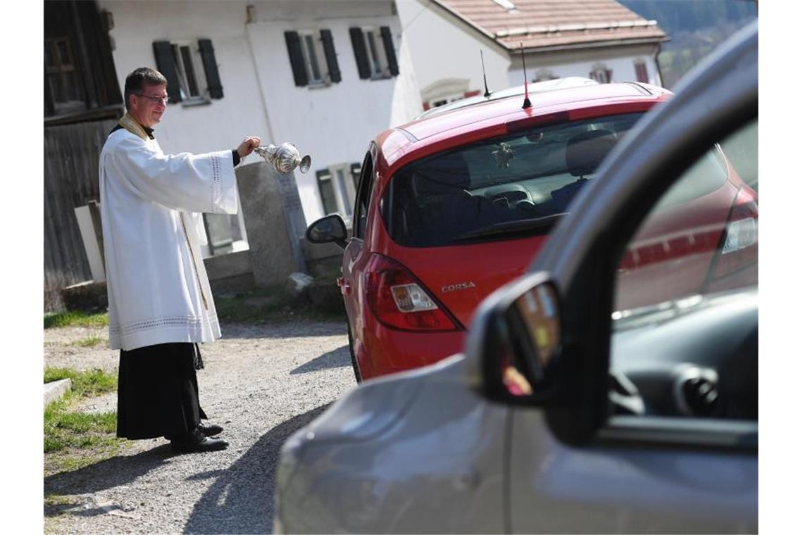 Pfarrer Rudolf Scherer führt die Speisenweihe per Drive-in durch. Foto: Angelika Warmuth/dpa