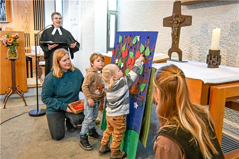 Pfarrerin Ute Bögel (links) macht den Glauben bei den Kleinkindgottesdiensten an wechselnden Orten in Backnang greifbar. Beim Auftaktgottesdienst in der Petruskirche in Sachsenweiler durften die Kinder Blätter und Äpfel an einen Baum hängen. Foto: Tobias Sellmaier