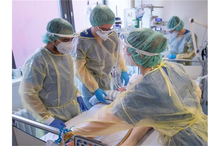 Pflegende und eine Ärztin kümmern sich auf einer Corona-Intensivstation in Offenbach um einen Patienten. Foto: Sebastian Gollnow/dpa