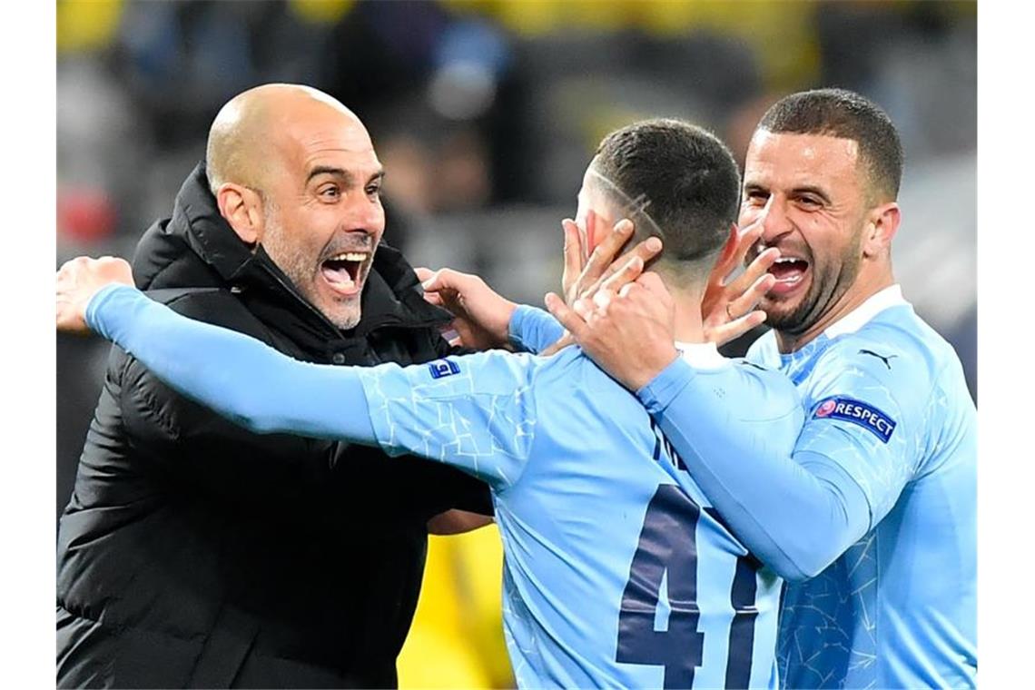 Phil Foden (M) von Manchester jubelt nach seinem Treffer zum 2:1 gegen Dortmund mit Kyle Walker (r) und Trainer Pep Guardiola. Foto: Martin Meissner/AP-Pool/dpa